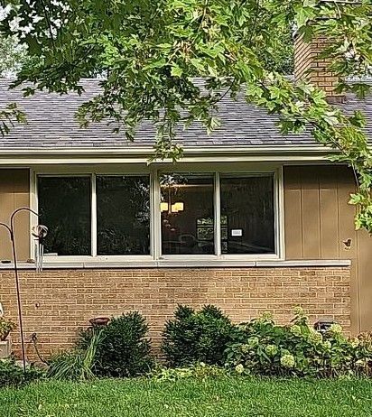 A Brick House with A Lot of Windows and A Chimney — Carver, MN — TJ Exteriors Inc.