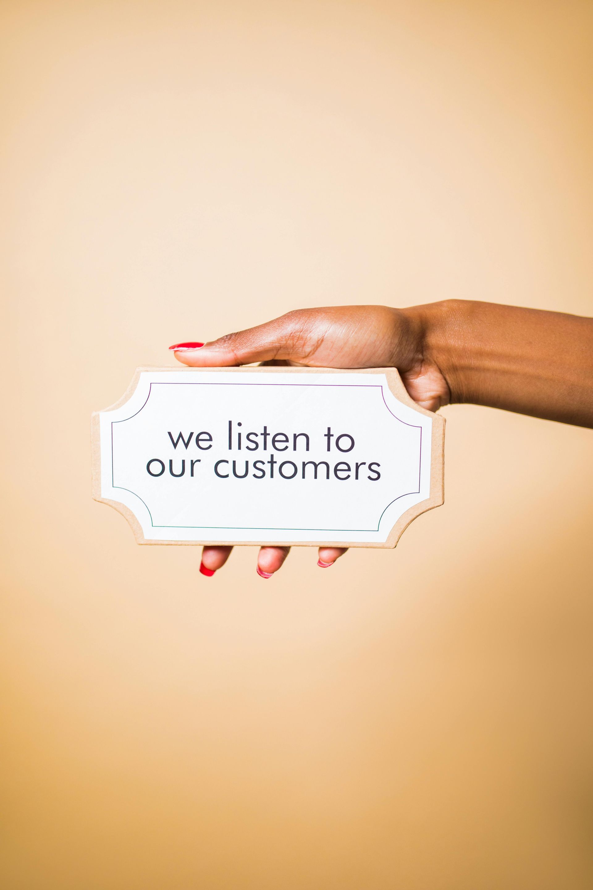A woman is holding a sign that says `` we listen to our customers ''.
