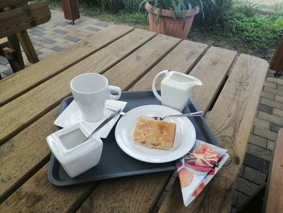 Ein Holztisch mit einem Tablett mit Essen und einer Tasse Kaffee darauf.