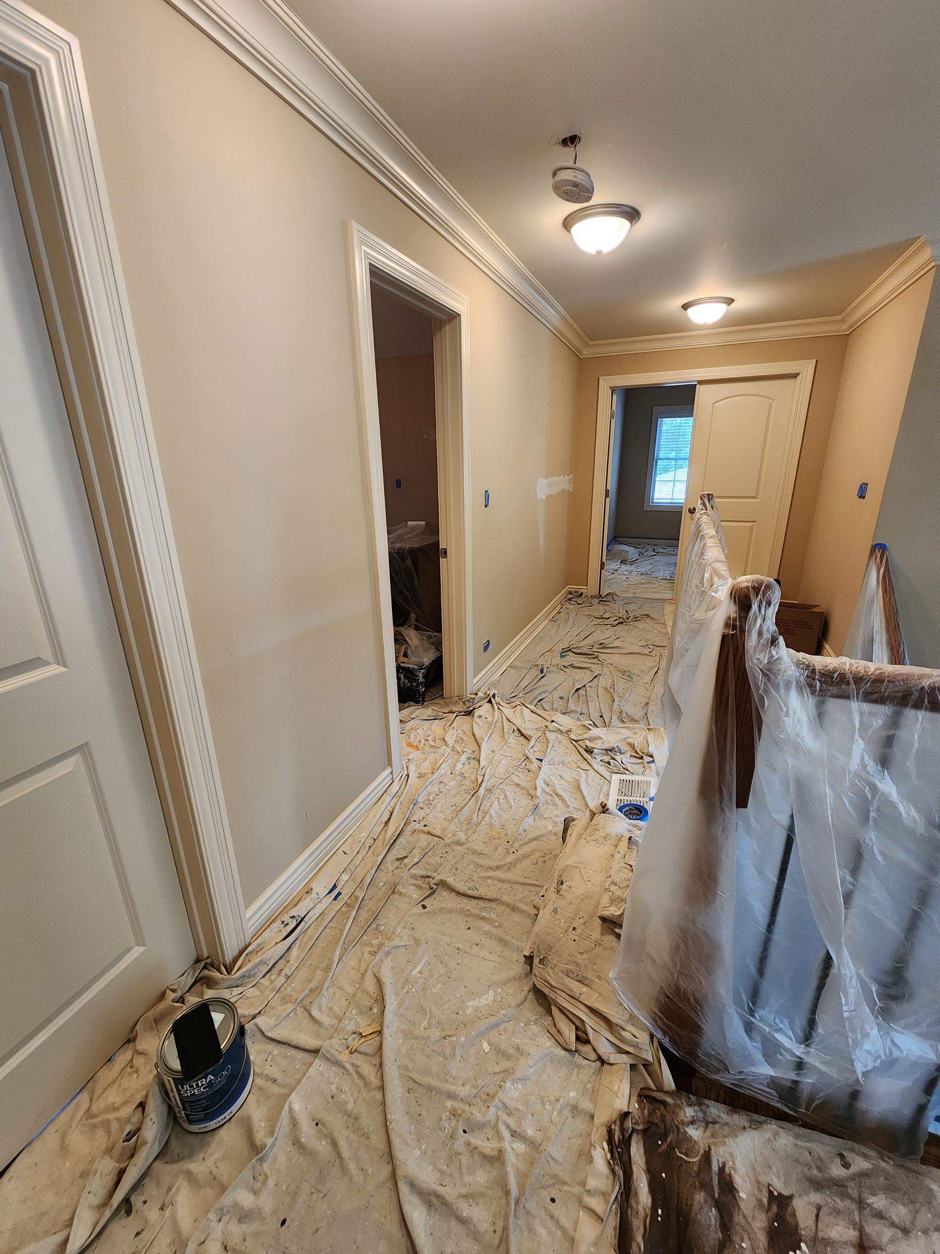 A hallway is being painted in a house.