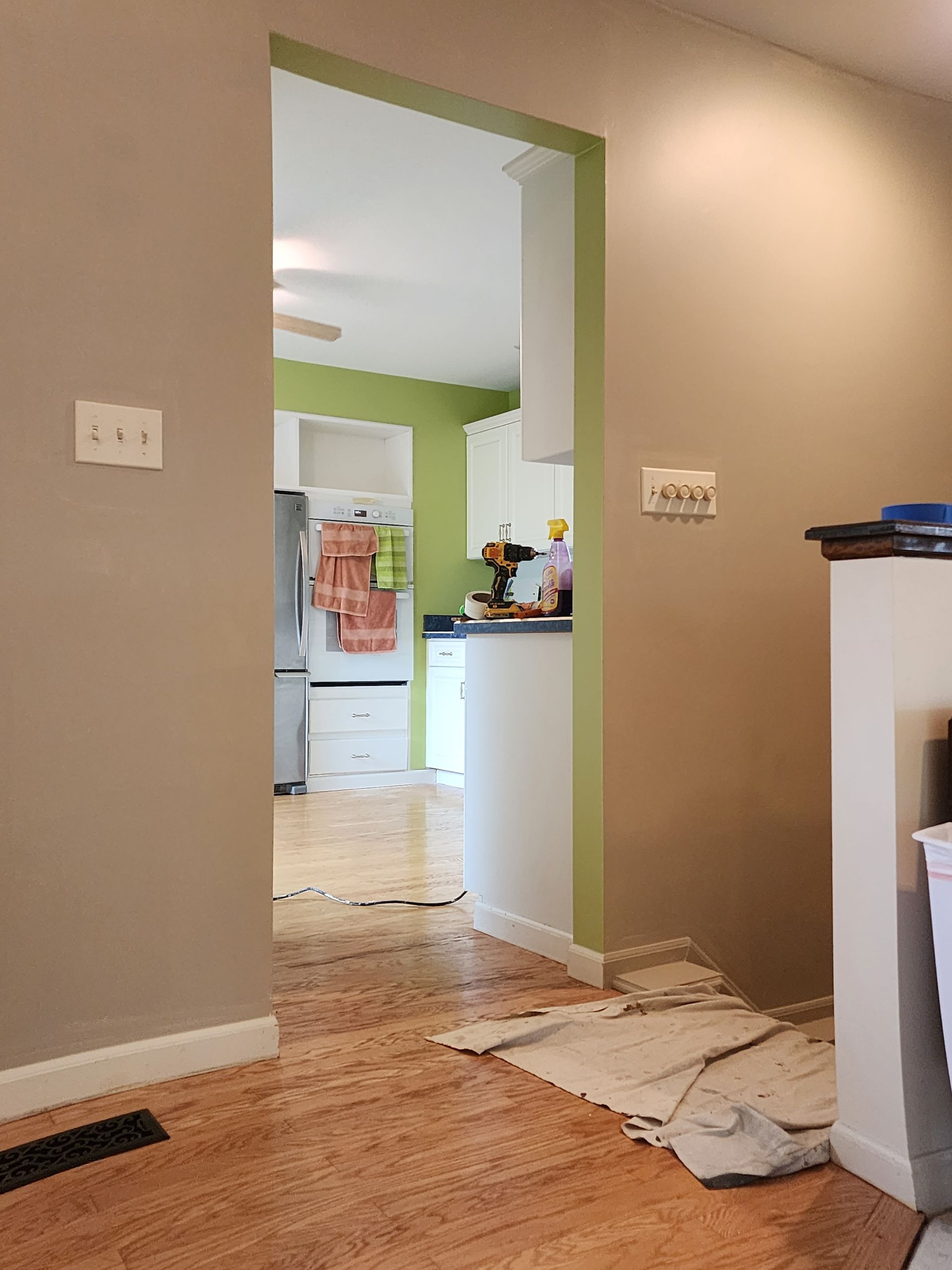 A kitchen with hardwood floors and a doorway leading to the kitchen.