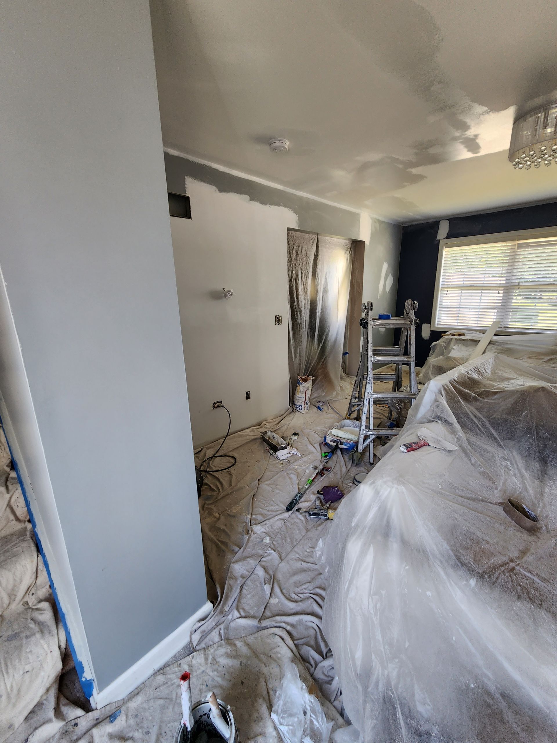 A living room is being painted in a house.