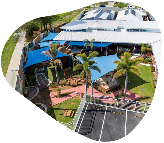 Aerial view of a colorful outdoor children's play area with shade sails, grass, and various play structures.