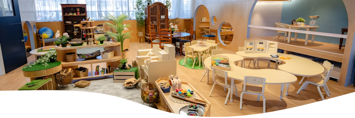 Playroom with wooden furniture, toys, and tables. Bright, open space.