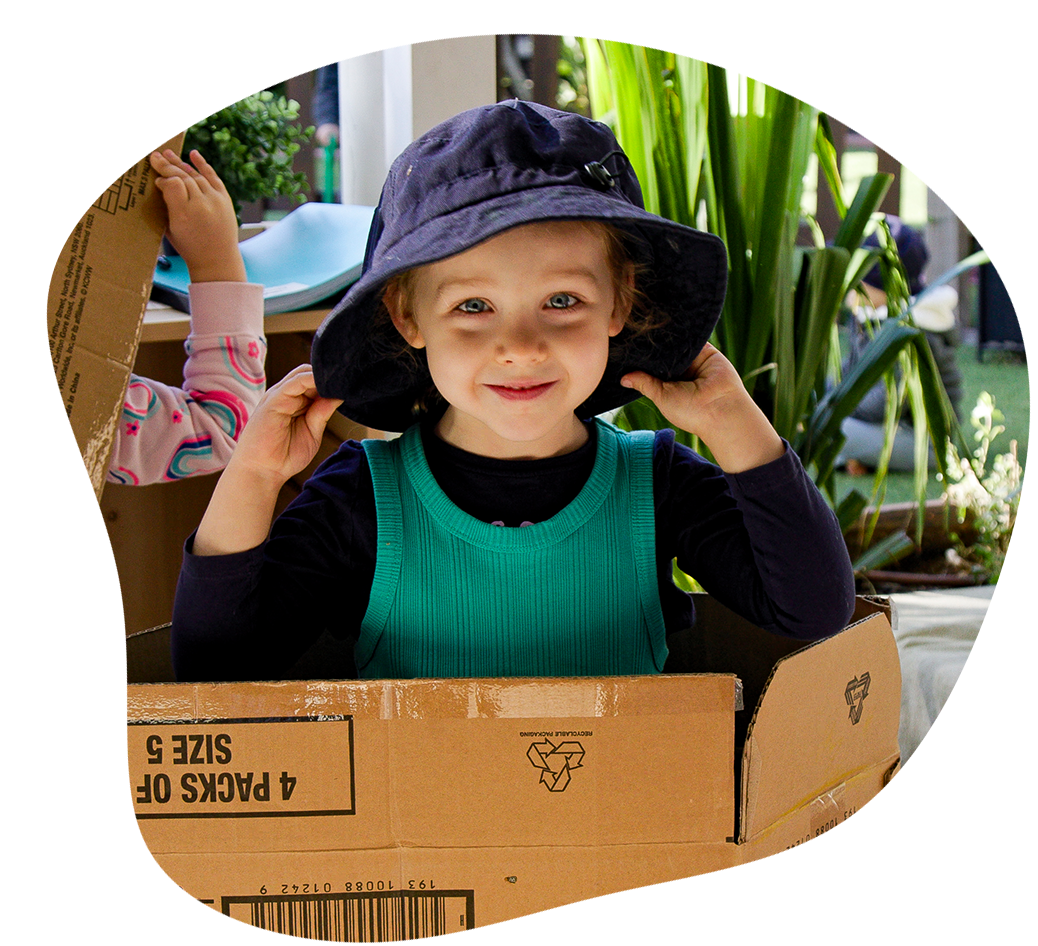 Child playing in cardboard box