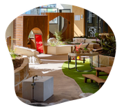 Outdoor playground with sandstone bricks, a winding path and wooden play spaces.