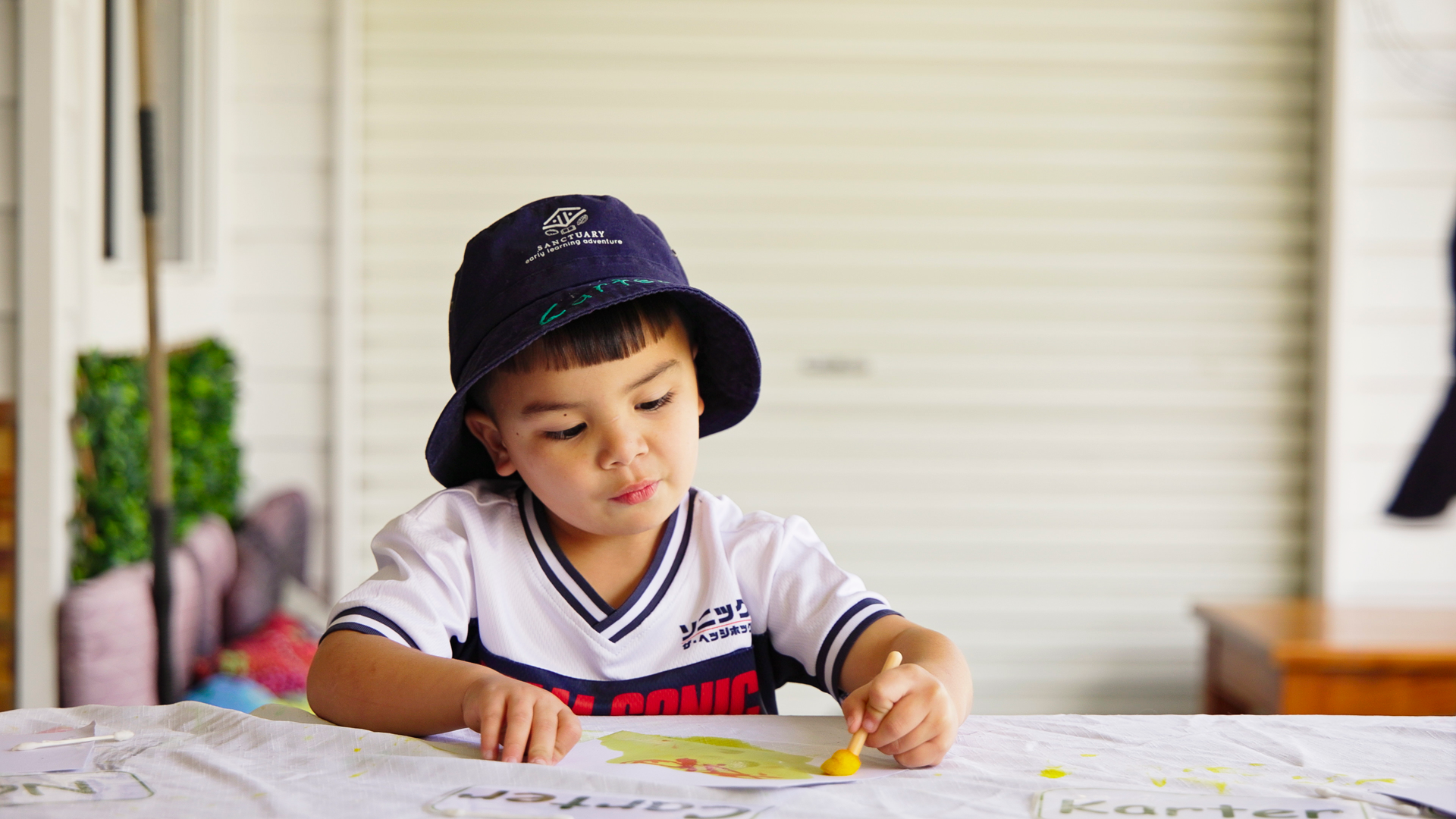 child draws at table outside