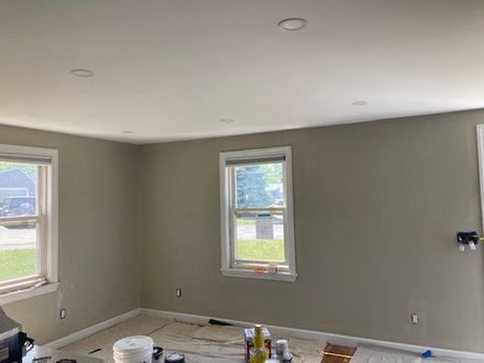 Interior room with painted walls and ceiling, two windows, and recessed lighting.