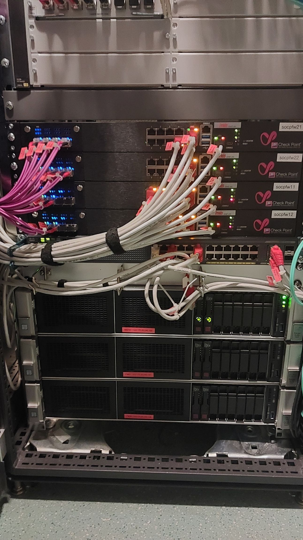 Serverrack mit gebündelten Netzwerkkabeln und Geräten in einem Rechenzentrumsschrank