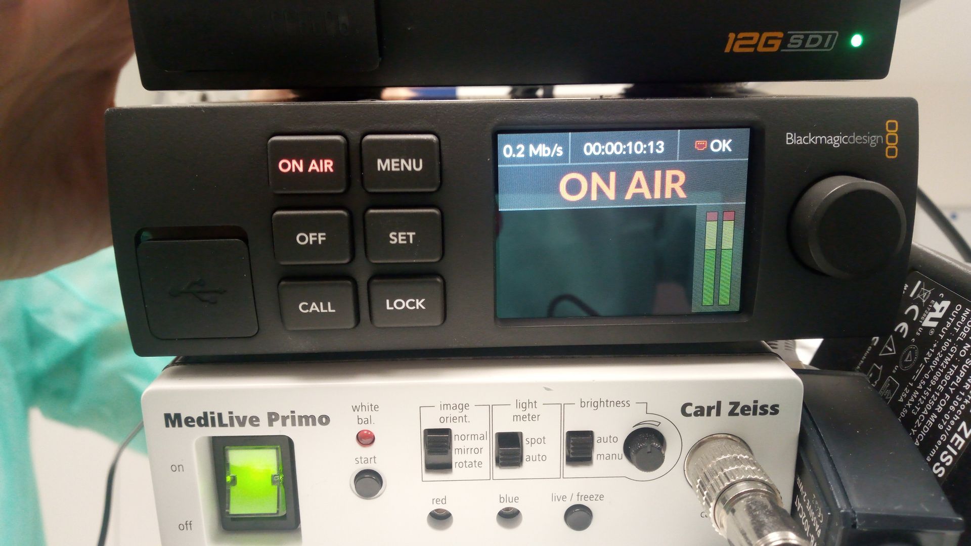 Radiostudio-Bedienfeld mit einer „ON AIR“-Anzeige und beleuchteten Tasten neben einer Mikrofon-Schnittstelle.