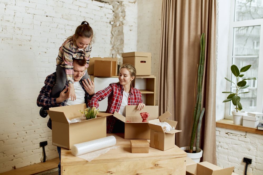 A man is carrying a child on his shoulders in a living room.