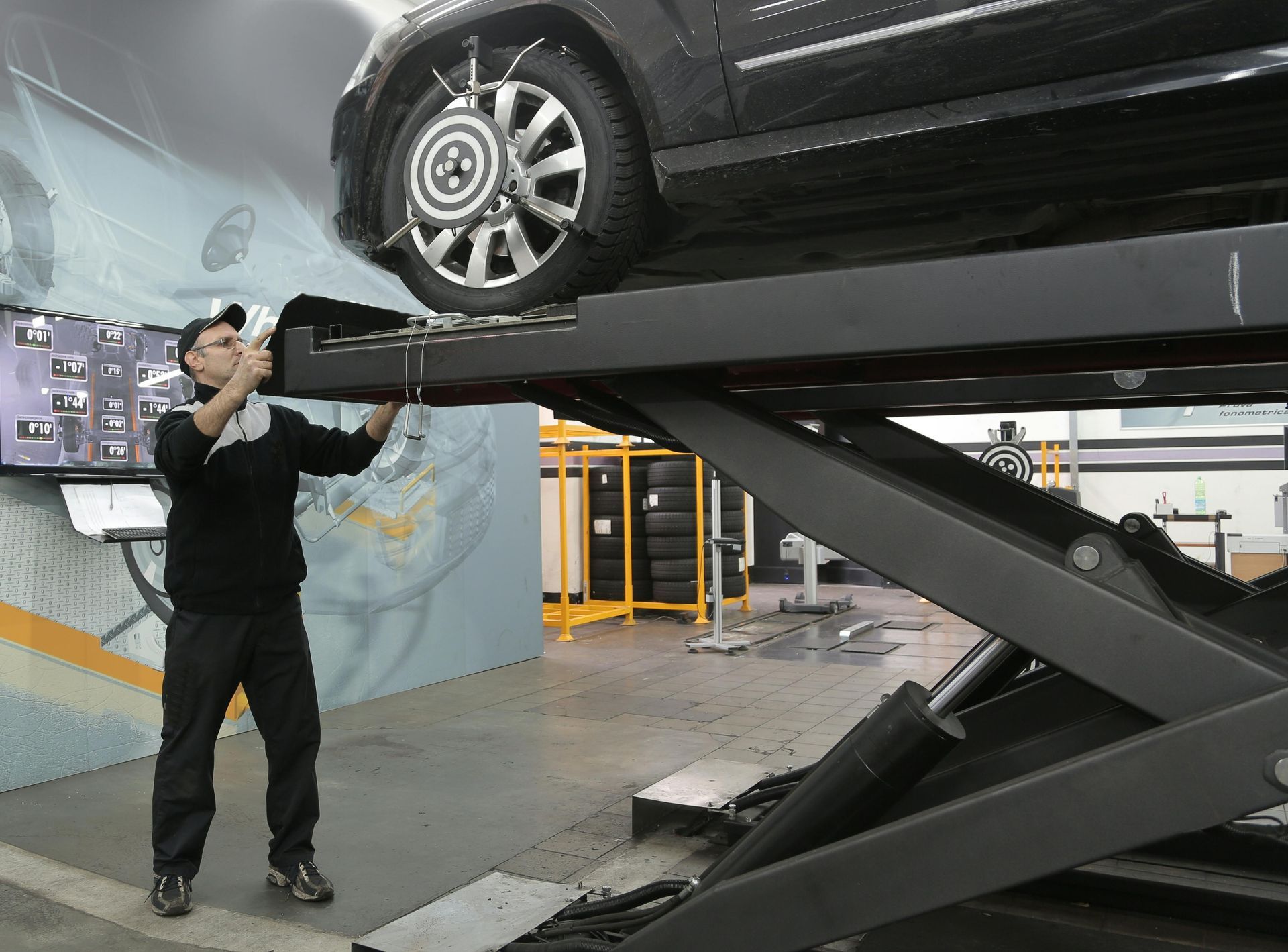 Technician Performing Wheel Alignment On Vehicle Lift | Middleton Motors