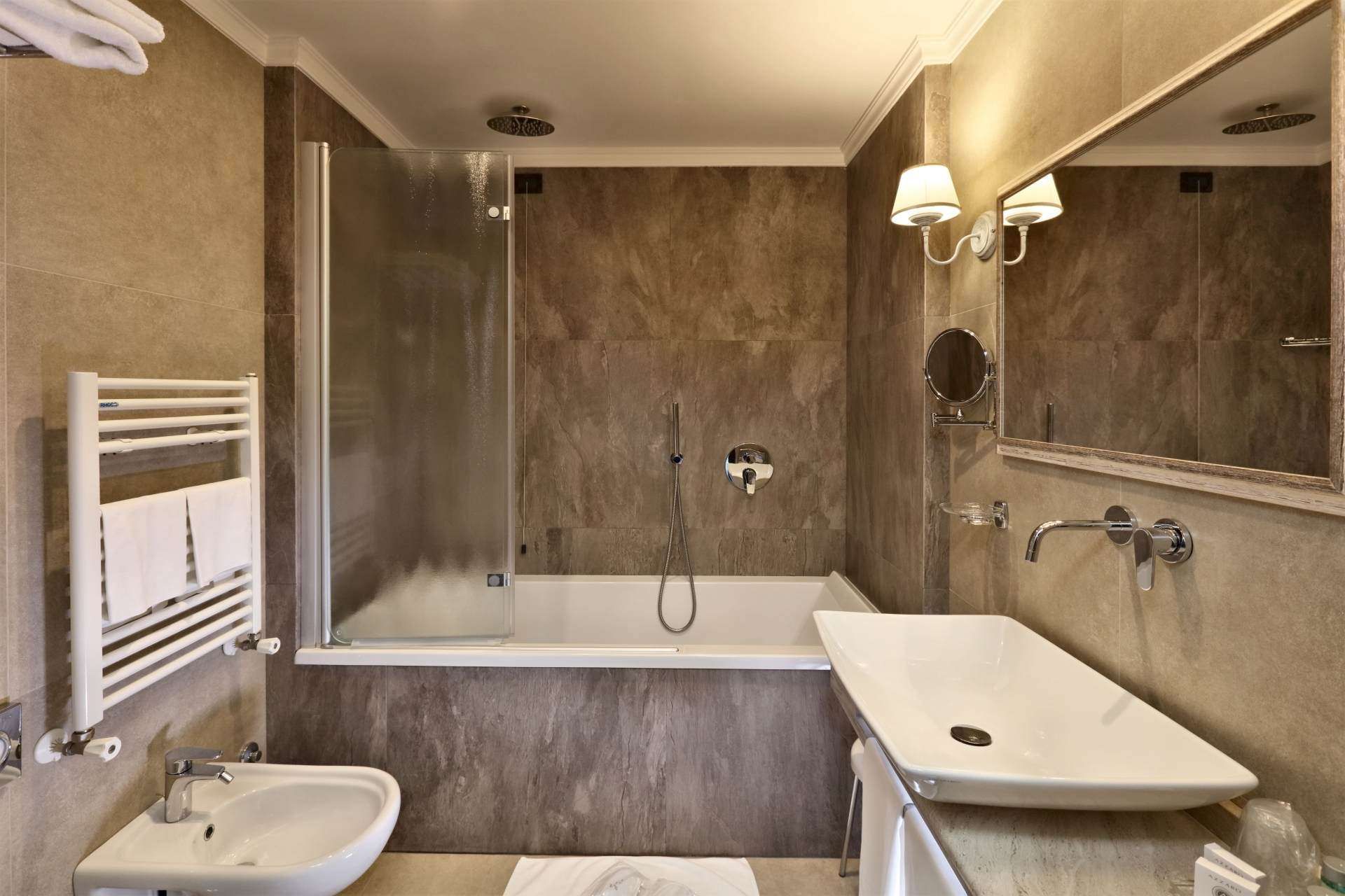 Ein Badezimmer mit Badewanne, Waschbecken und Spiegel