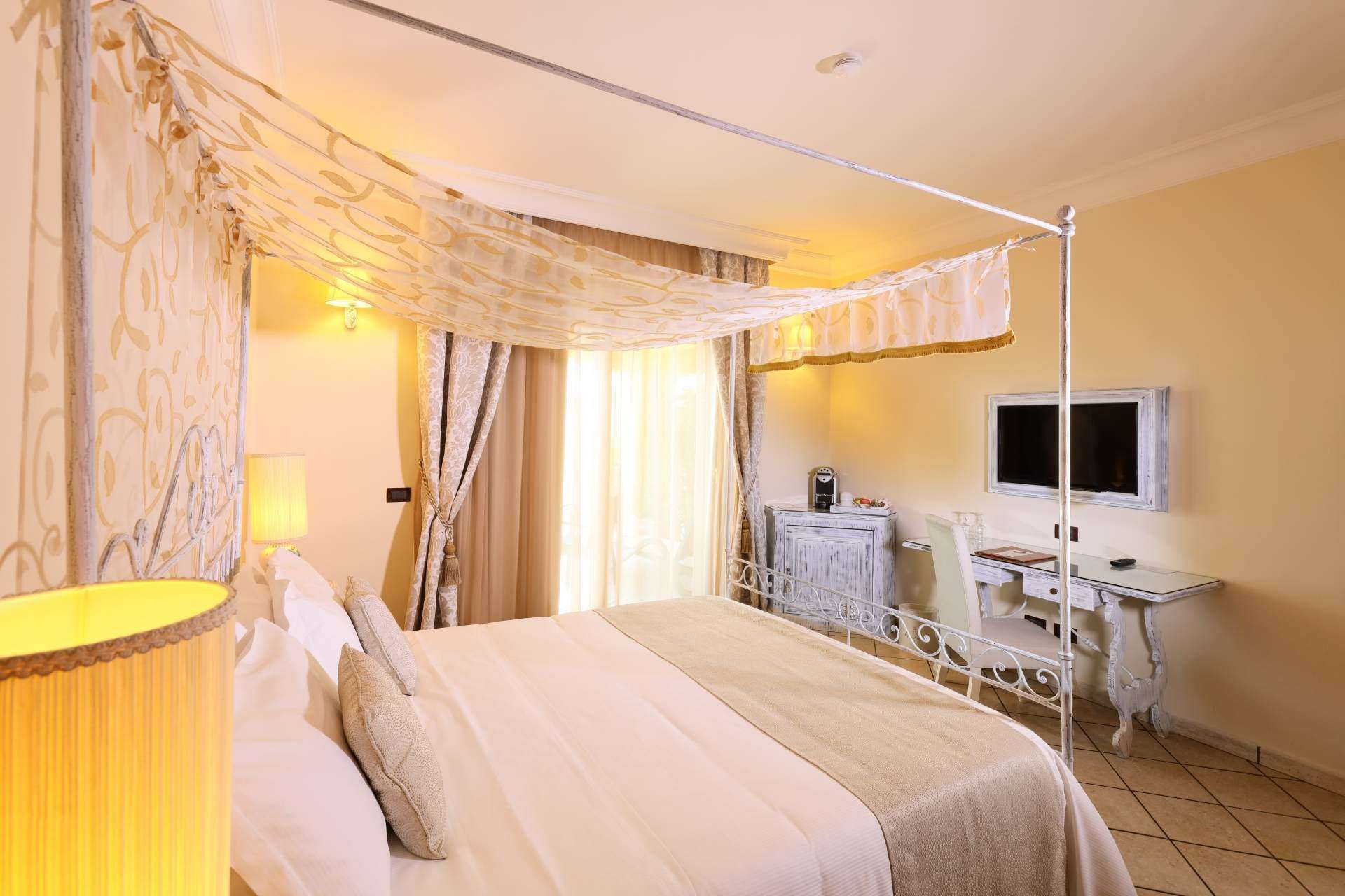 Ein Hotelzimmer mit Himmelbett und Flachbildfernseher