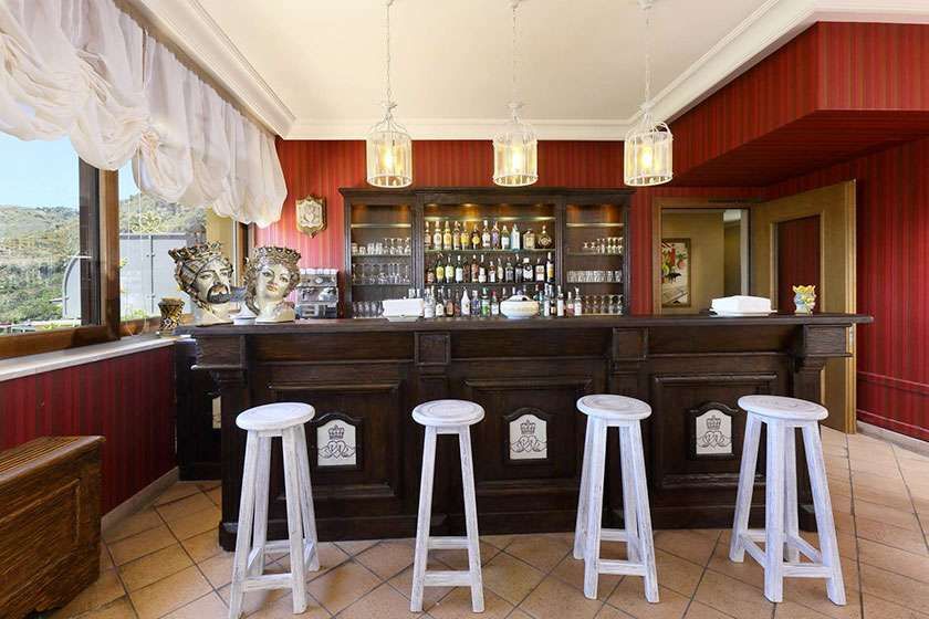 Eine Bar mit vier weißen Hockern davor