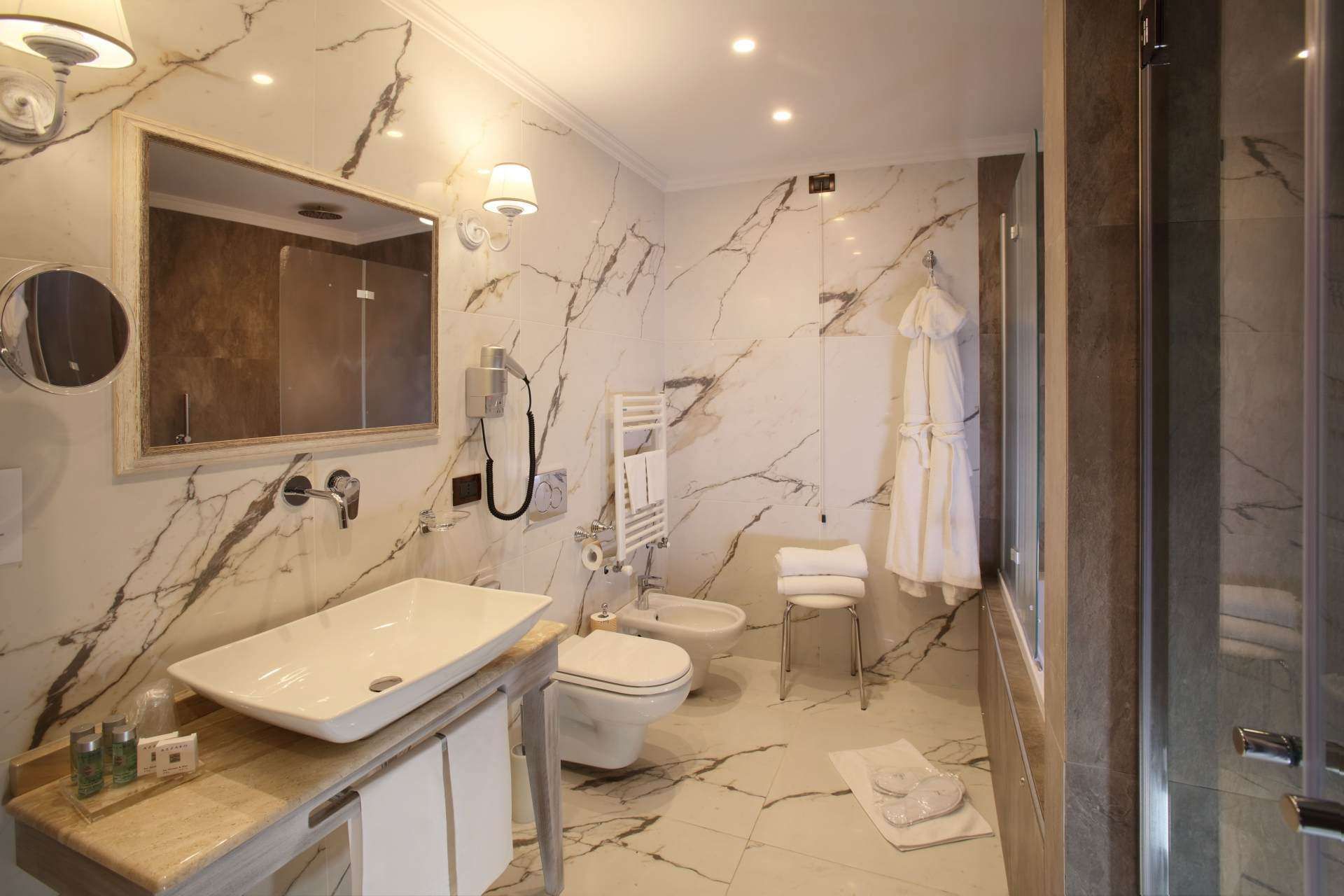 Ein Badezimmer mit Waschbecken, Toilette, Bidet und Spiegel.