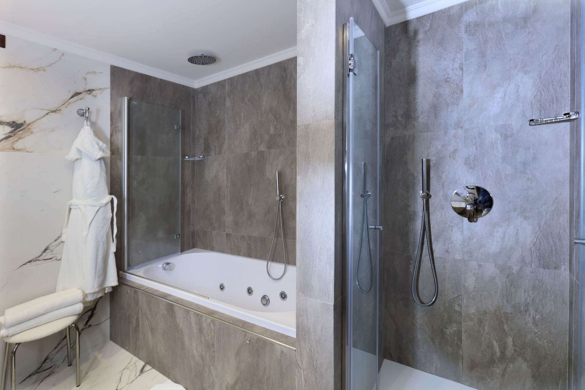 Ein Badezimmer mit Whirlpool und ebenerdiger Dusche.