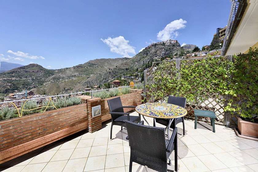 Auf dem Balkon mit Blick auf die Berge gibt es einen Tisch und Stühle.