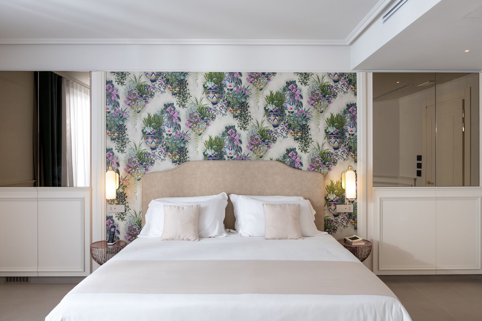 Ein Schlafzimmer mit einem Bett und einer Blumentapete an der Wand