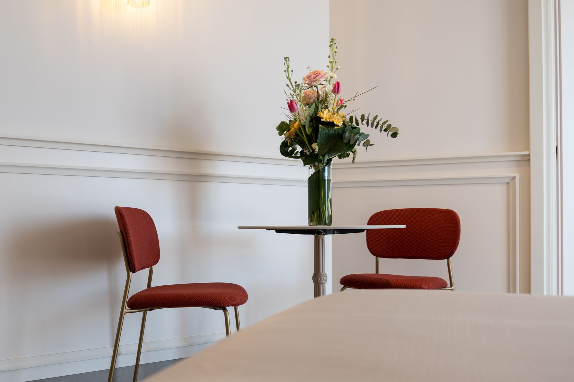 Ein Tisch und Stühle in einem Raum mit einer Vase mit Blumen darauf.