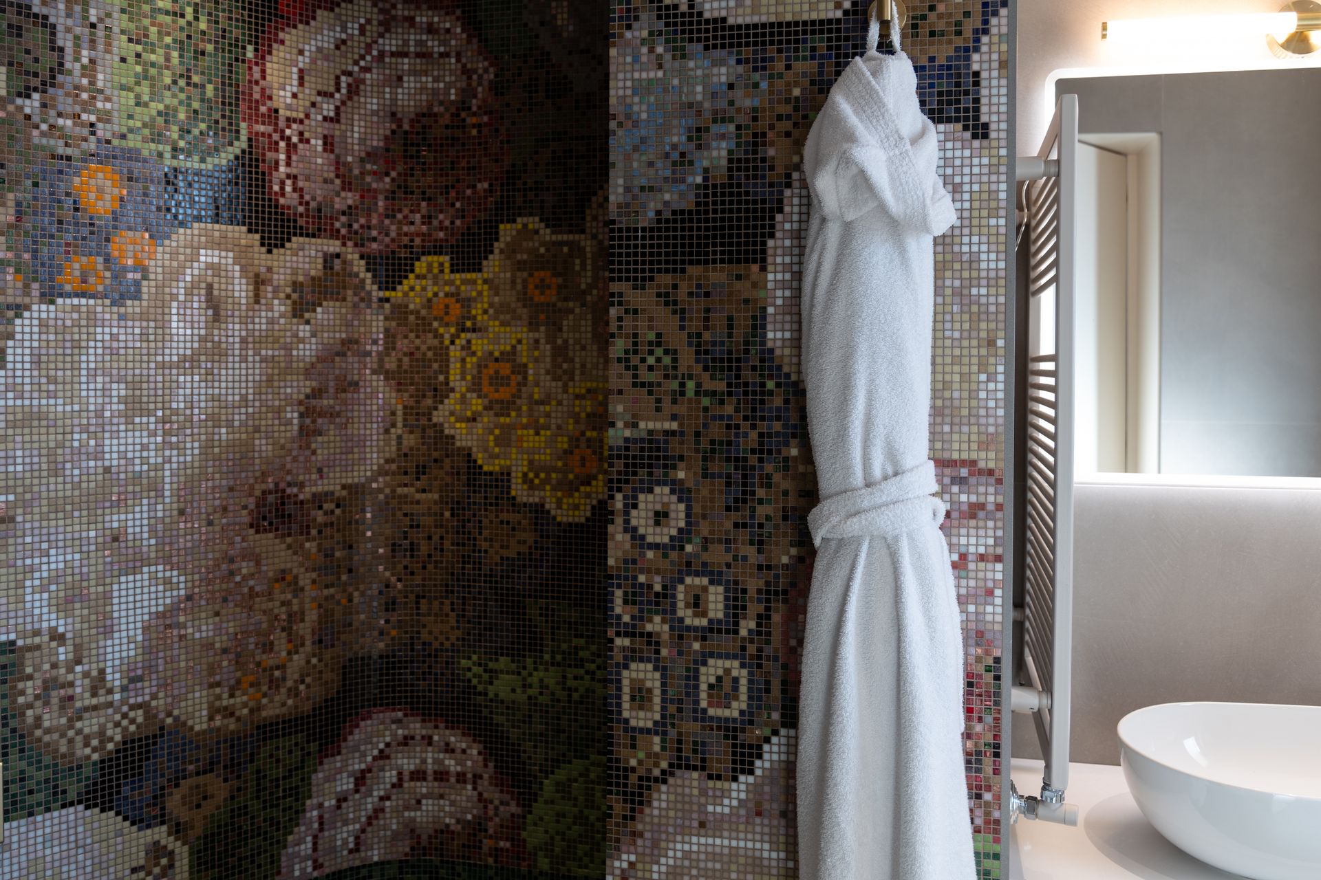 Ein Bademantel hängt in einem Badezimmer neben einem Waschbecken.