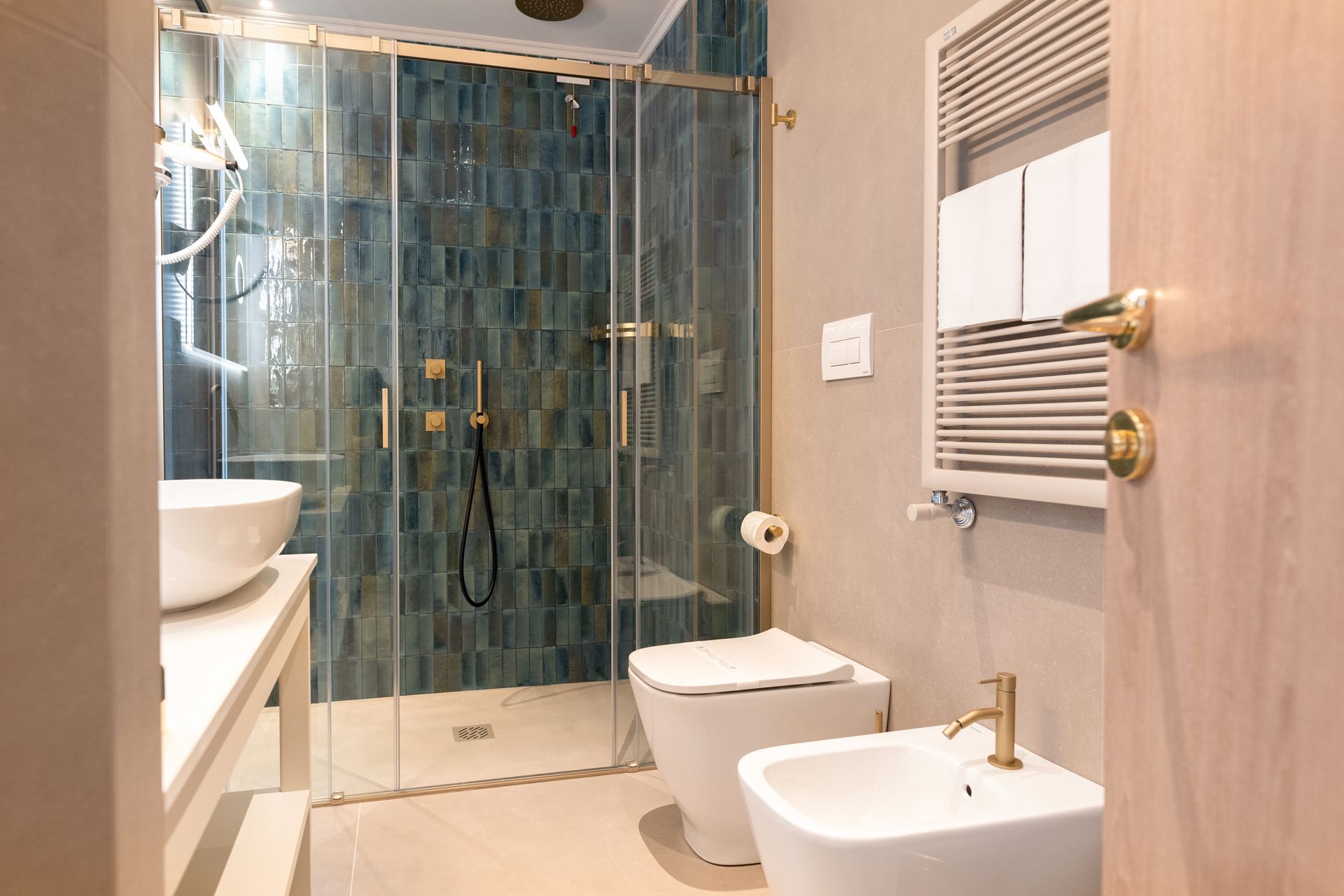 Ein Badezimmer mit Toilette, Bidet, Waschbecken und Dusche.