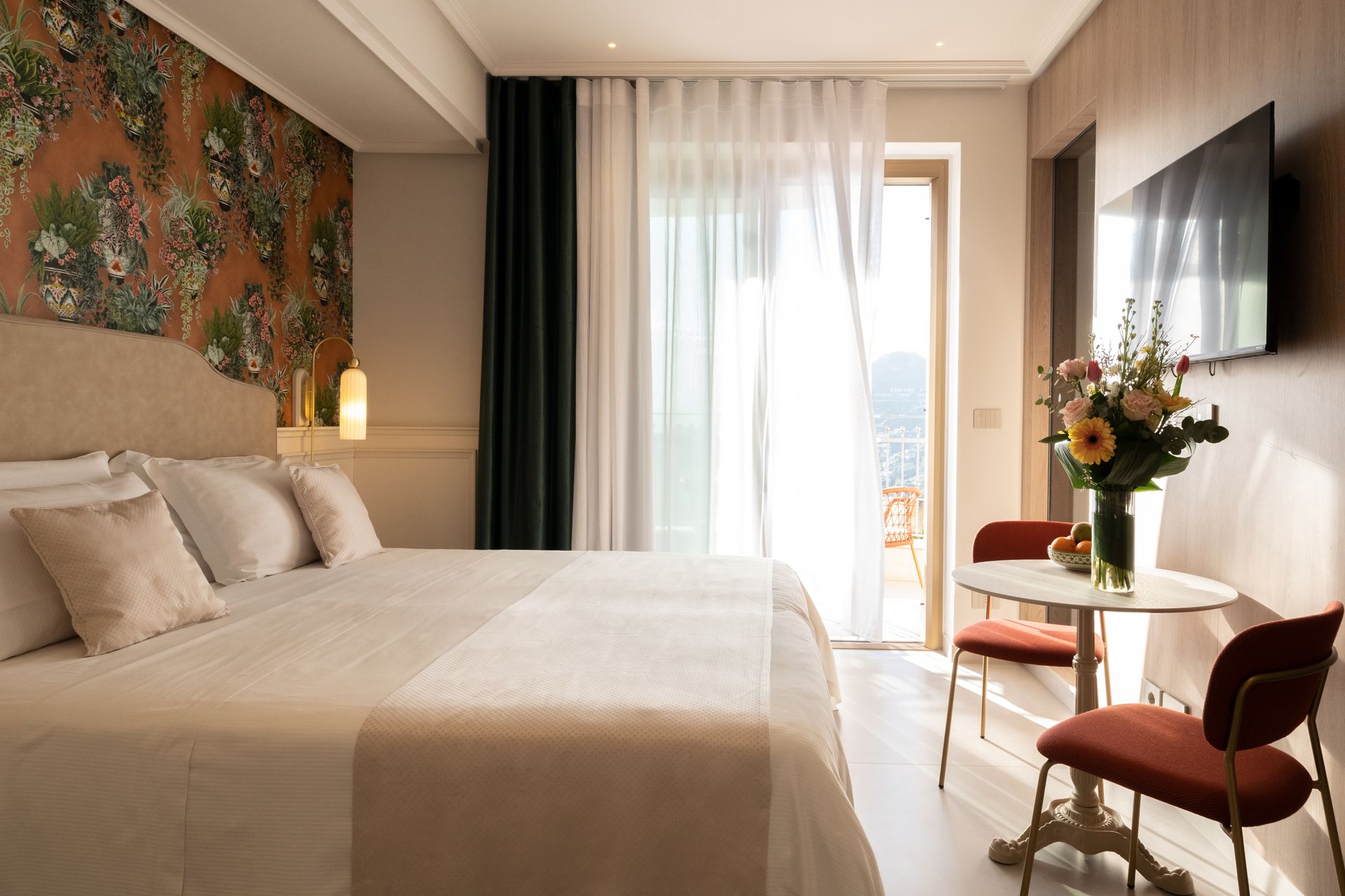 Ein Hotelzimmer mit Kingsize-Bett, Tisch und Stühlen.