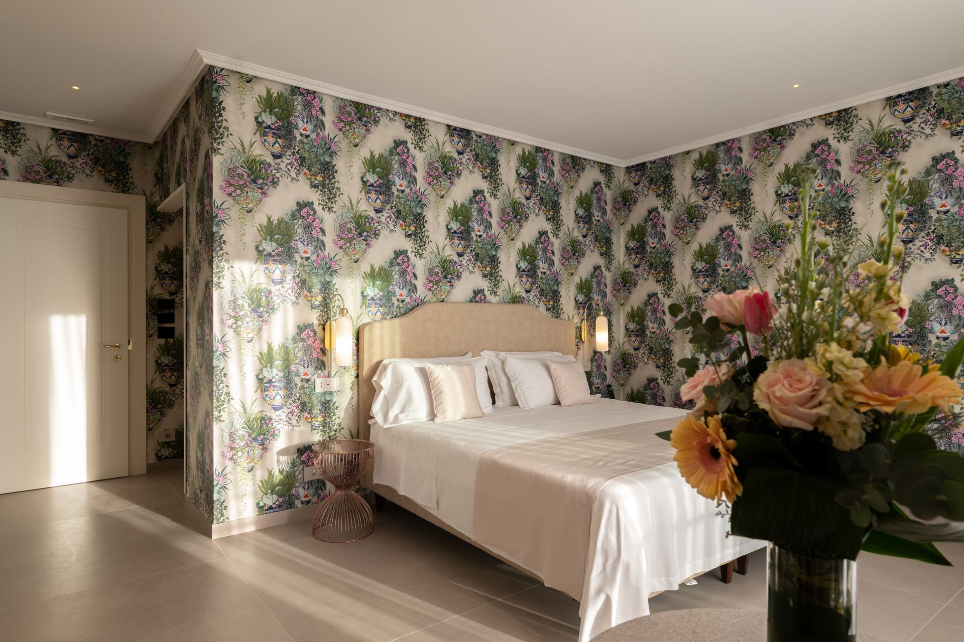 Ein Schlafzimmer mit einem Bett und einer Blumenvase auf dem Boden.