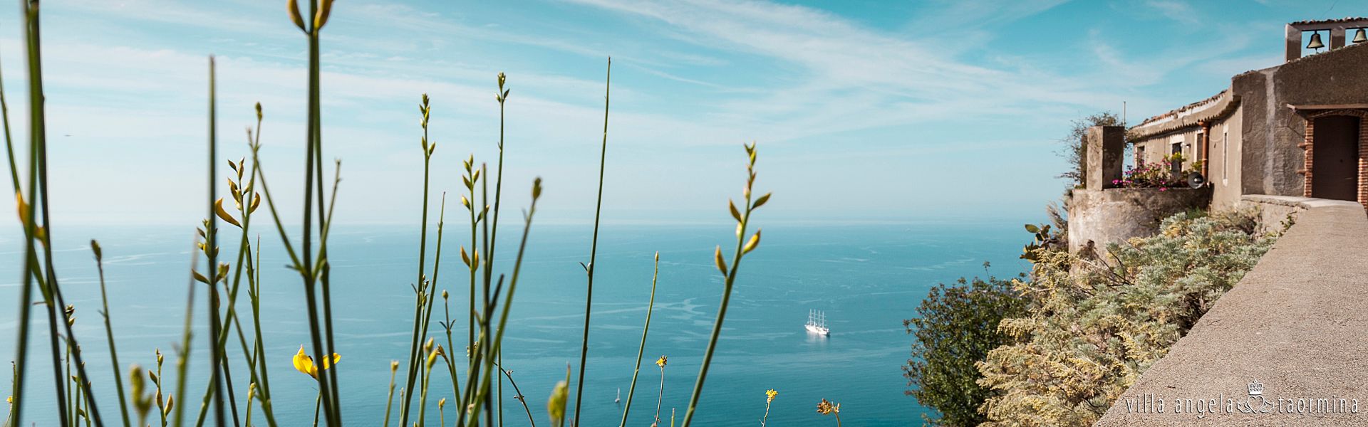 Eine Klippe mit Blick auf den Ozean und einem Gebäude im Hintergrund.