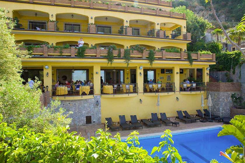 Ein großes gelbes Gebäude mit einem Swimmingpool davor