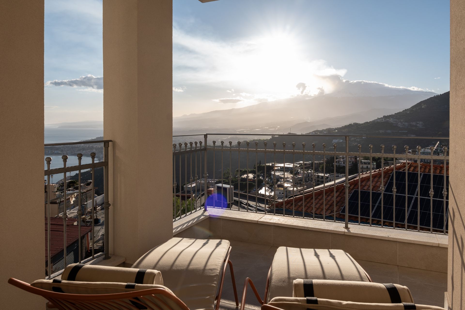 Deux chaises longues sont assises sur un balcon donnant sur l'océan.
