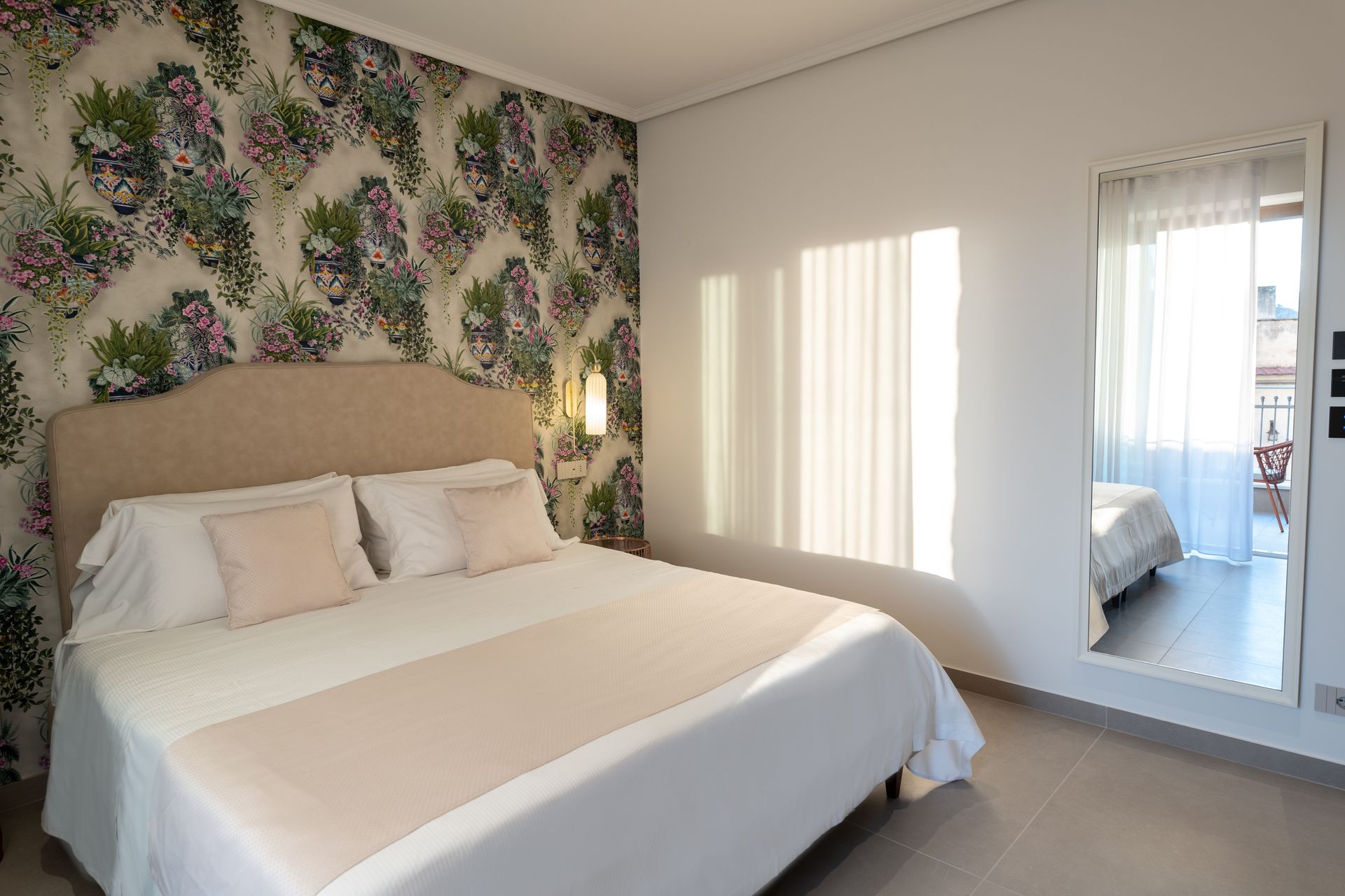 Une chambre avec un grand lit et un miroir.