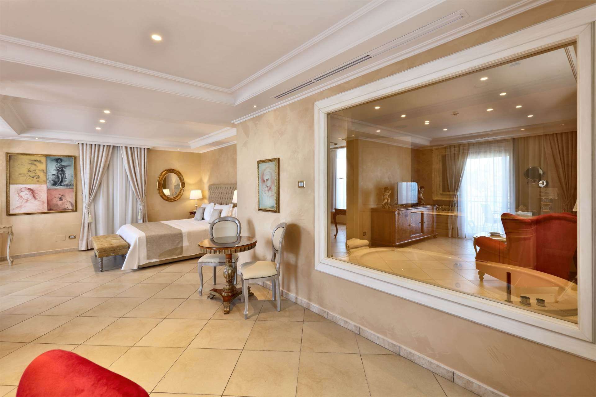 A hotel room with a large window and a bed.