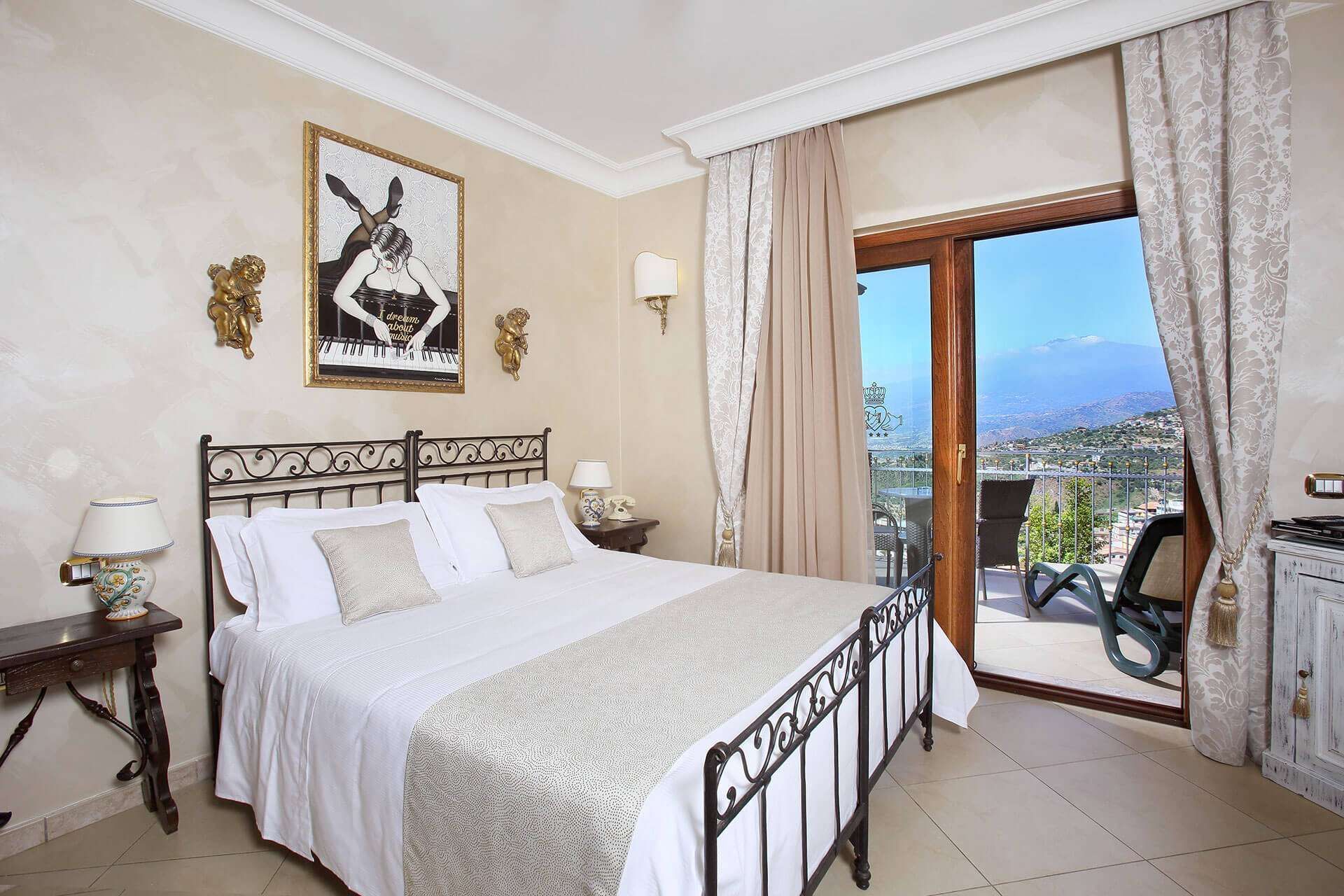 A bedroom with a large bed and a sliding glass door leading to a balcony.