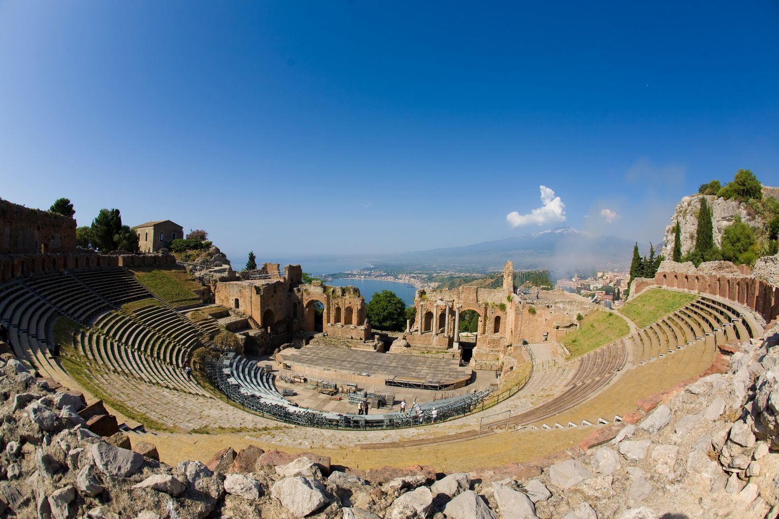 A view of an ancient amphitheater with a blue sky in the background.