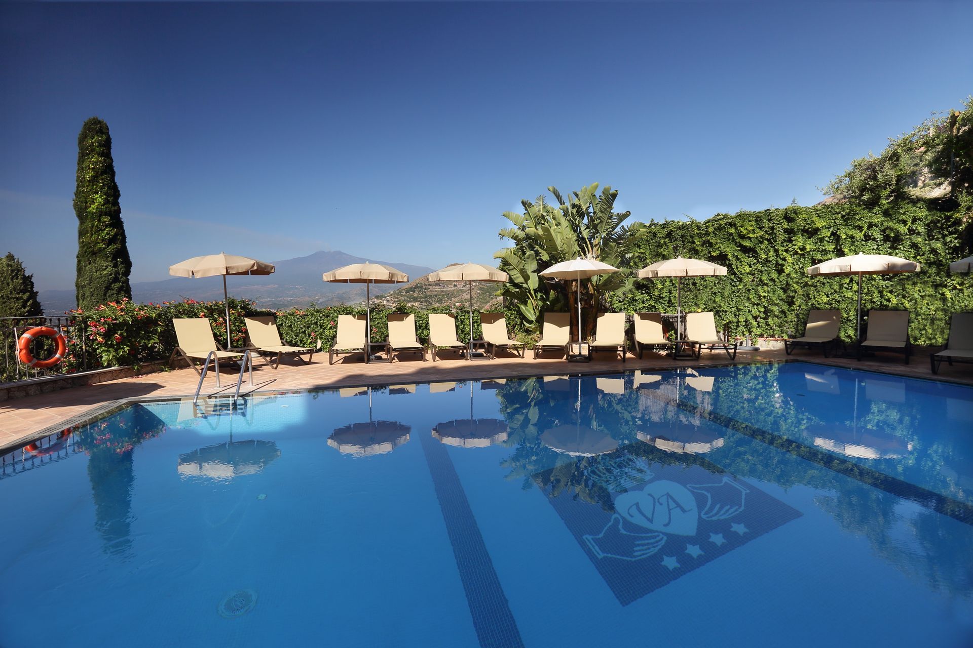 A large swimming pool with chairs and umbrellas around it