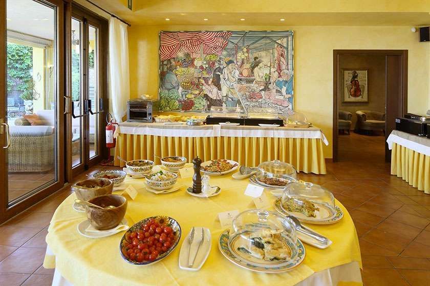 A table with plates of food on it in a room with a painting on the wall.