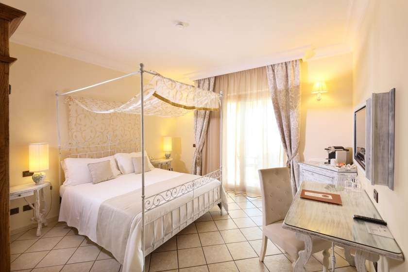 A bedroom with a canopy bed and a desk.