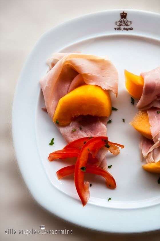 A white plate with slices of ham and peppers on it