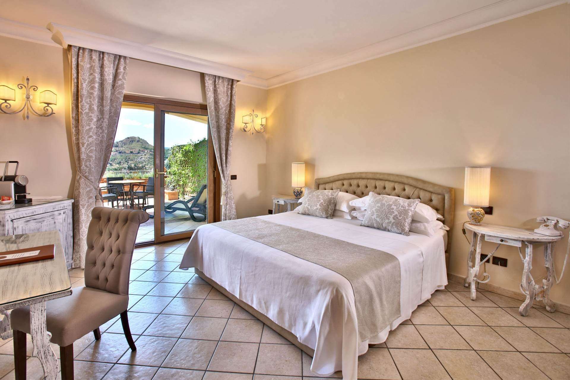 A hotel room with a large bed and a sliding glass door