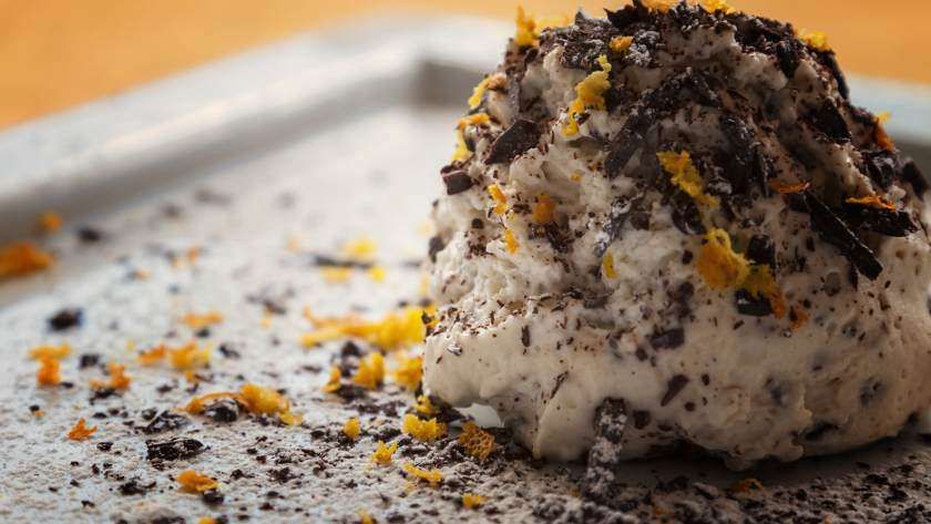 A close up of a dessert with chocolate shavings on a plate.