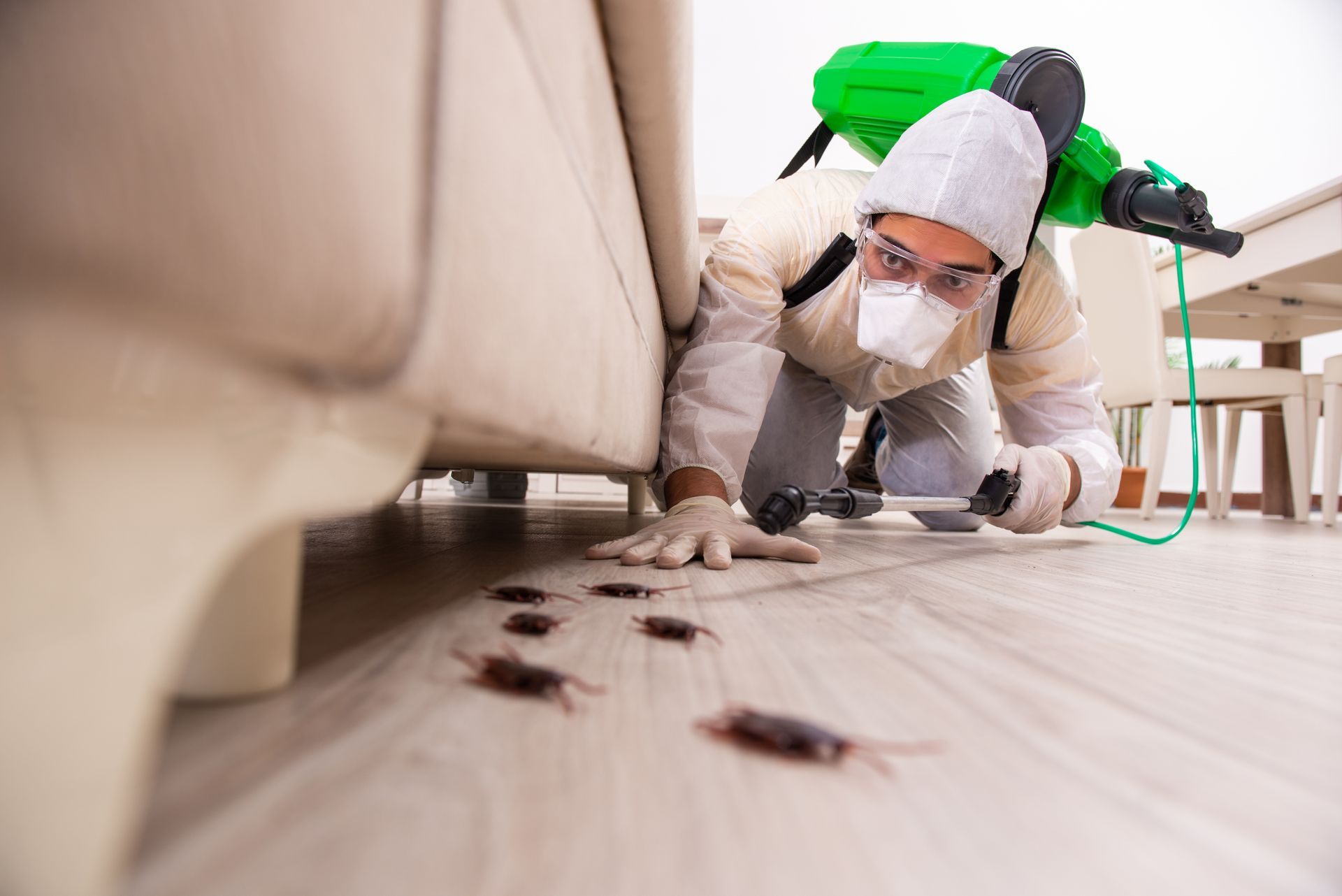 Person pressure-washing a wooden floor beside stairs indoors