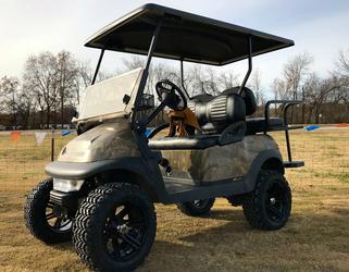A golf cart is parked in a grassy field.
