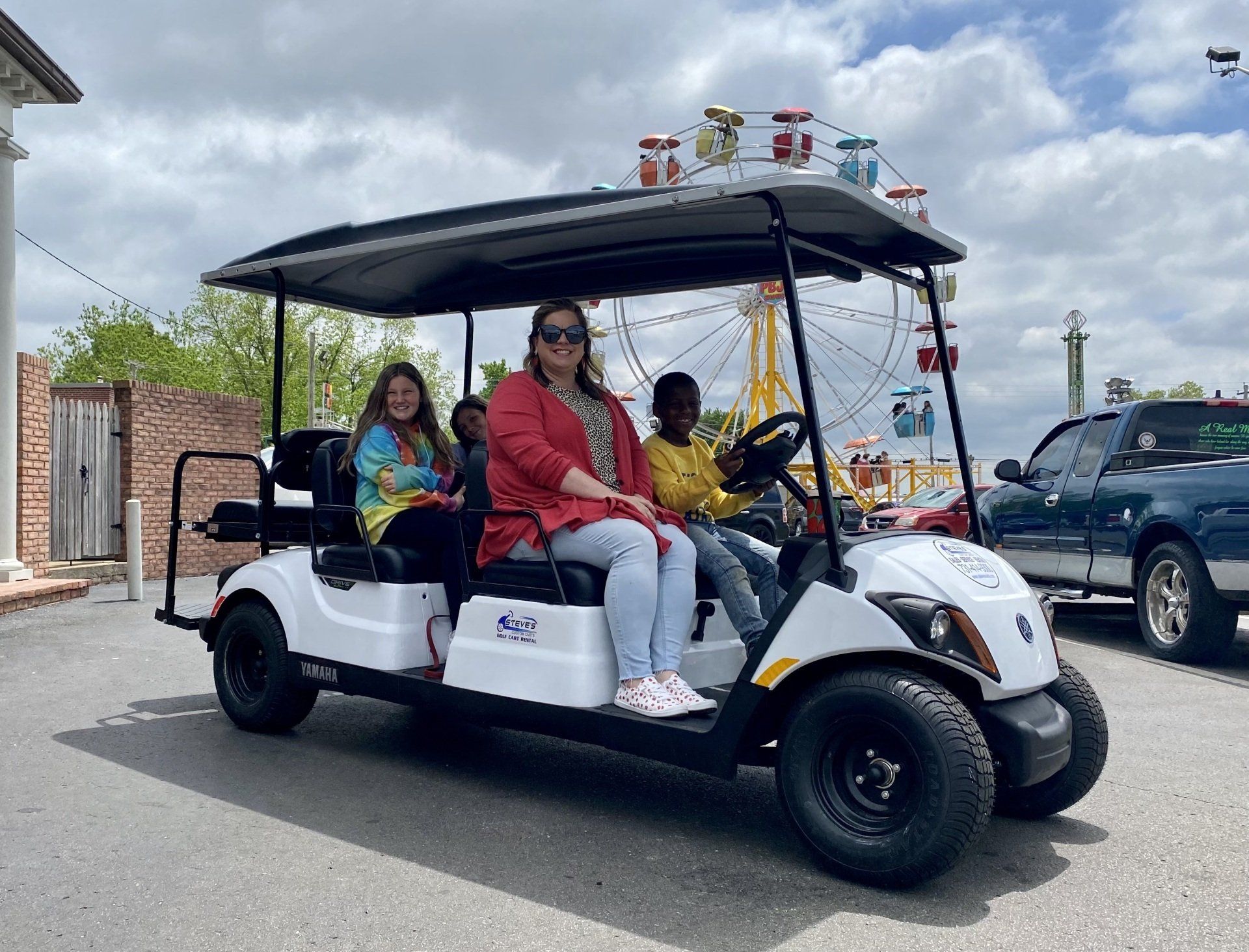 A group of people are riding in a golf cart.