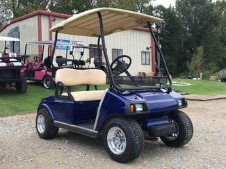 A blue golf cart is parked in front of a building.