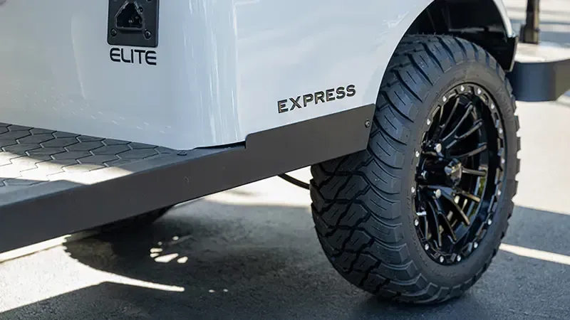 White Elite Express trailer with black off-road wheel and tire on pavement