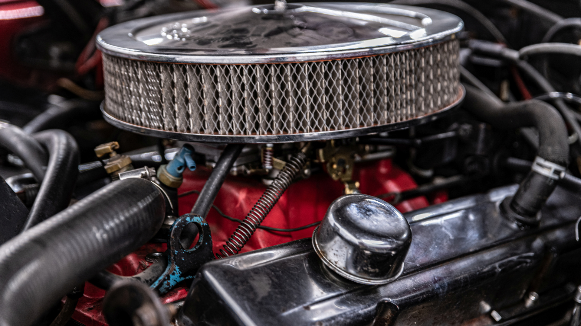 A close up of a car engine with a air filter.