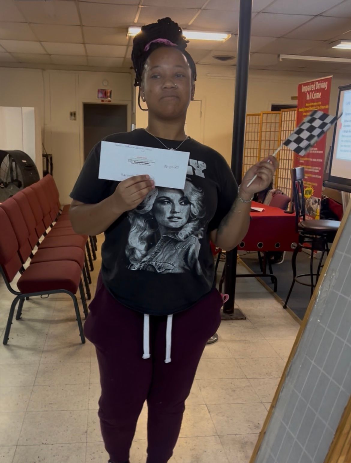 Person holding a prize and checkered flag.
