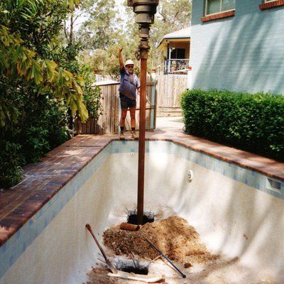 Steel screw piles supporting an existing pool
