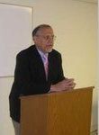 A man in a suit and tie is standing at a podium giving a speech.